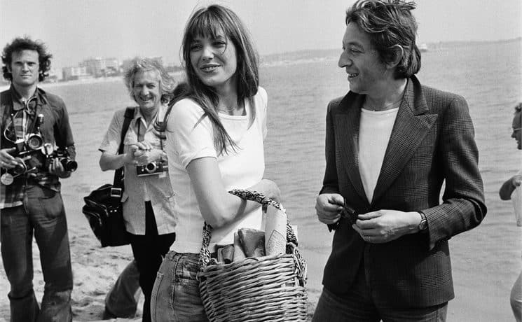 Imagem mostra Jane Birkin e Jean-Louis Dumas em um photoshoot na praia.